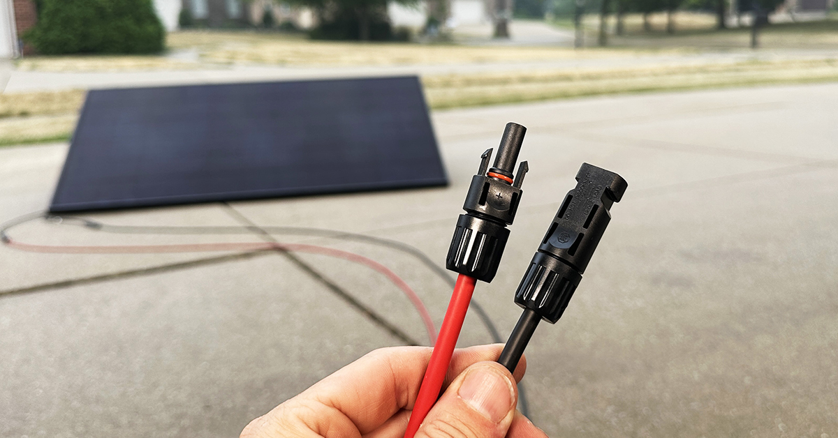 MC4 connectors on red and black solar cables, with a solar panel in the background