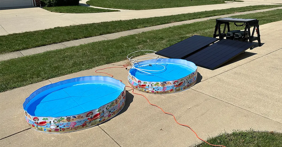An image of two kiddie pools filled with water set up next to solar panels.